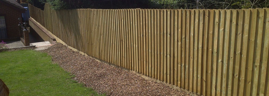 Vertical timber garden fence beside a lawn