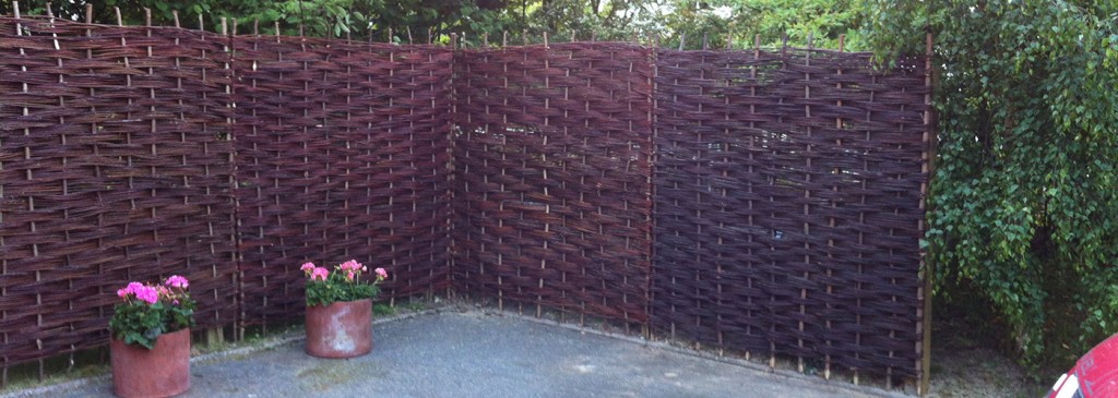 Woven garden screening beside a paved seating area