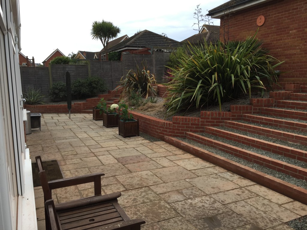 Terraced garden with brick steps and planted raised borders