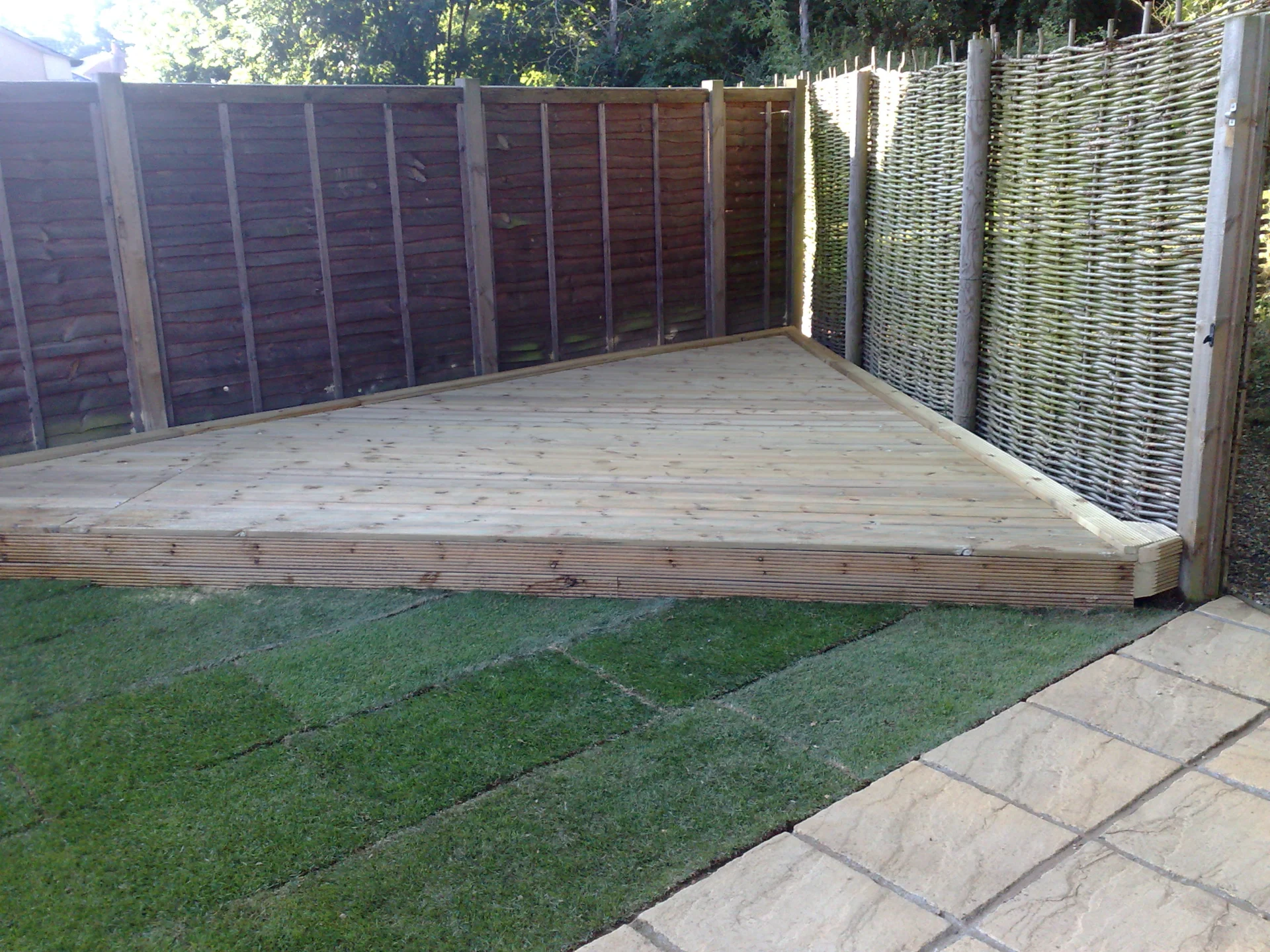 Raised timber decking enclosed by garden fencing