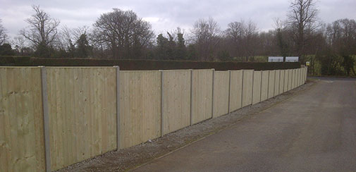 Long timber fence beside a paved access road