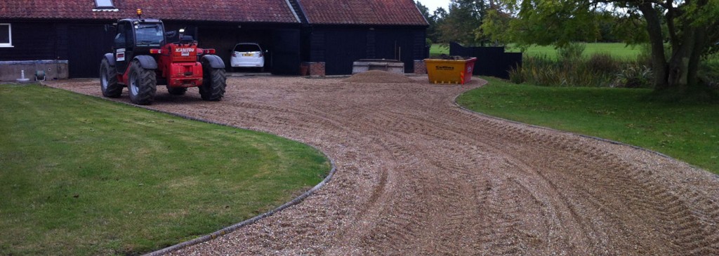 Curved gravel driveway leading to a rural property