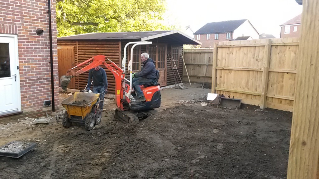 Garden excavation with a mini digger and wheelbarrow