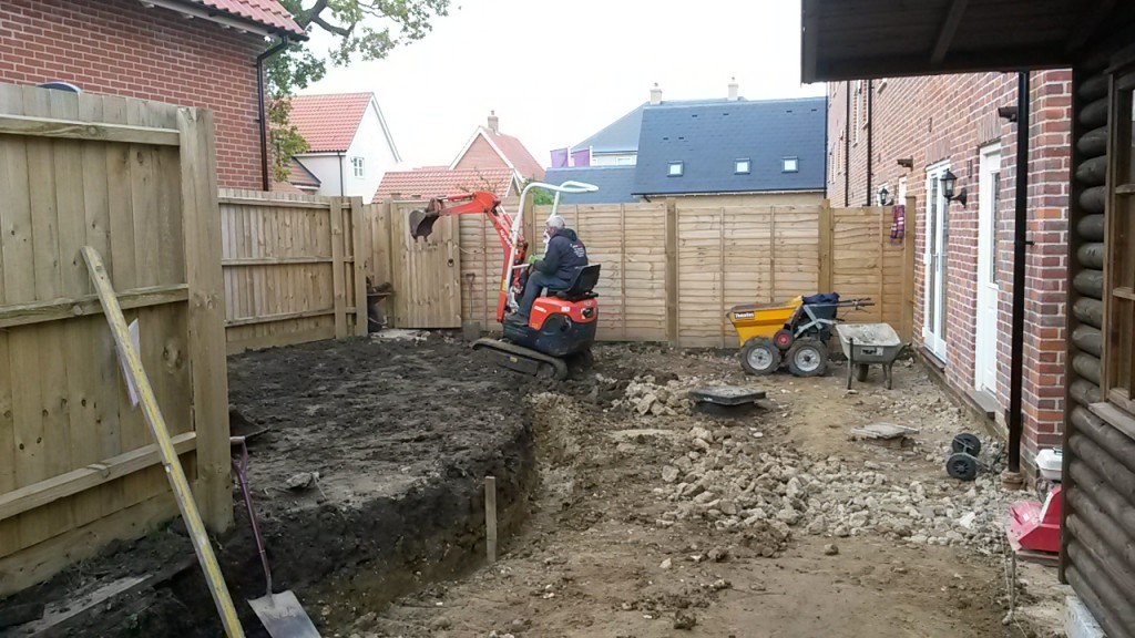 Trench and excavation beside a brick house
