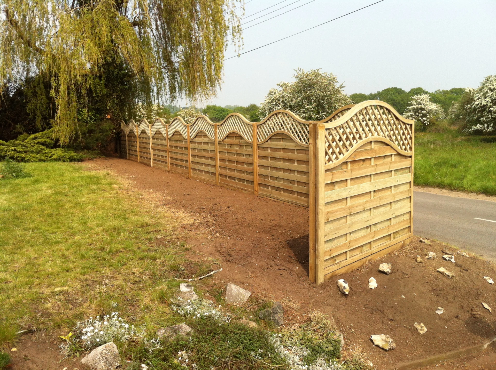 Timber boundary fencing with curved trellis tops