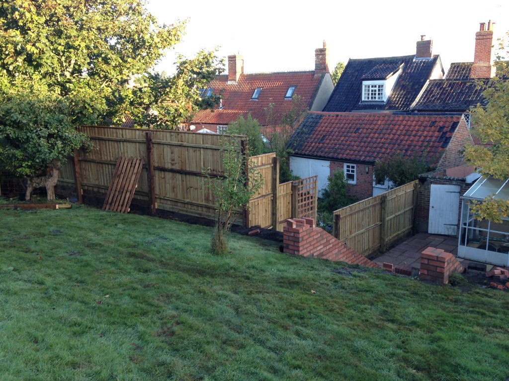 Timber boundary fencing above a sloping garden