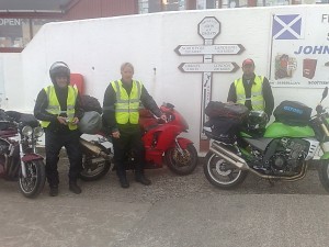 Motorcyclists and bikes at a road sign during a charity ride