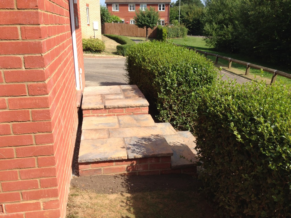 Completed stone paving and brick-edged front steps