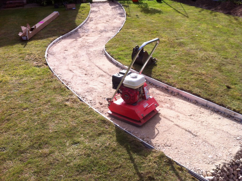 Compacting the base of a curved garden path