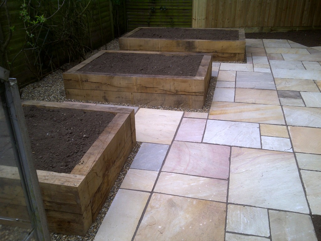 Timber raised beds beside stone paving