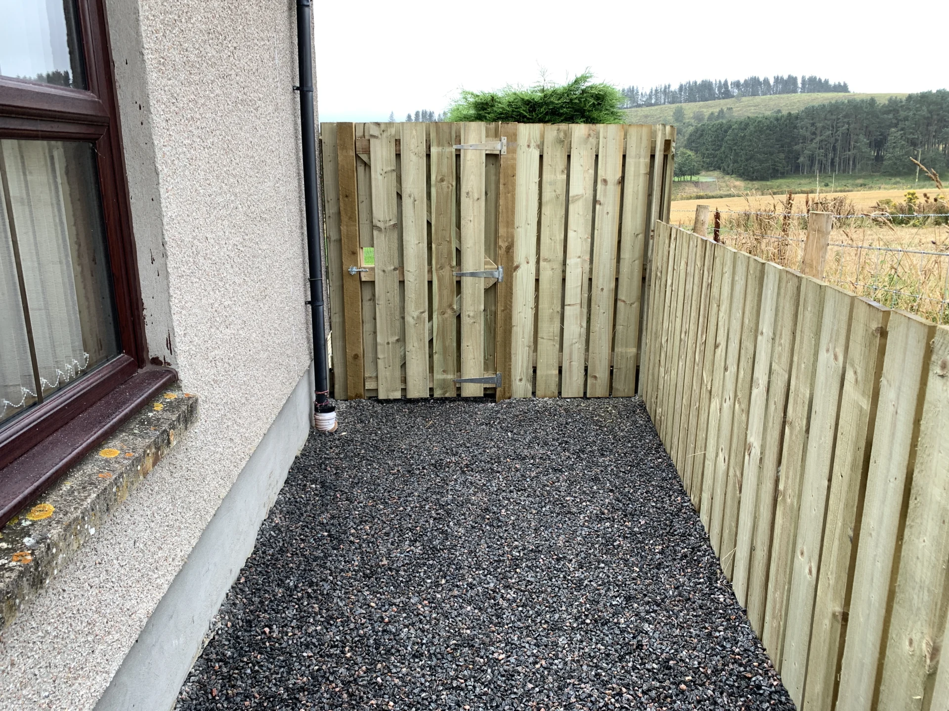 Timber gate and gravel side path beside new decking